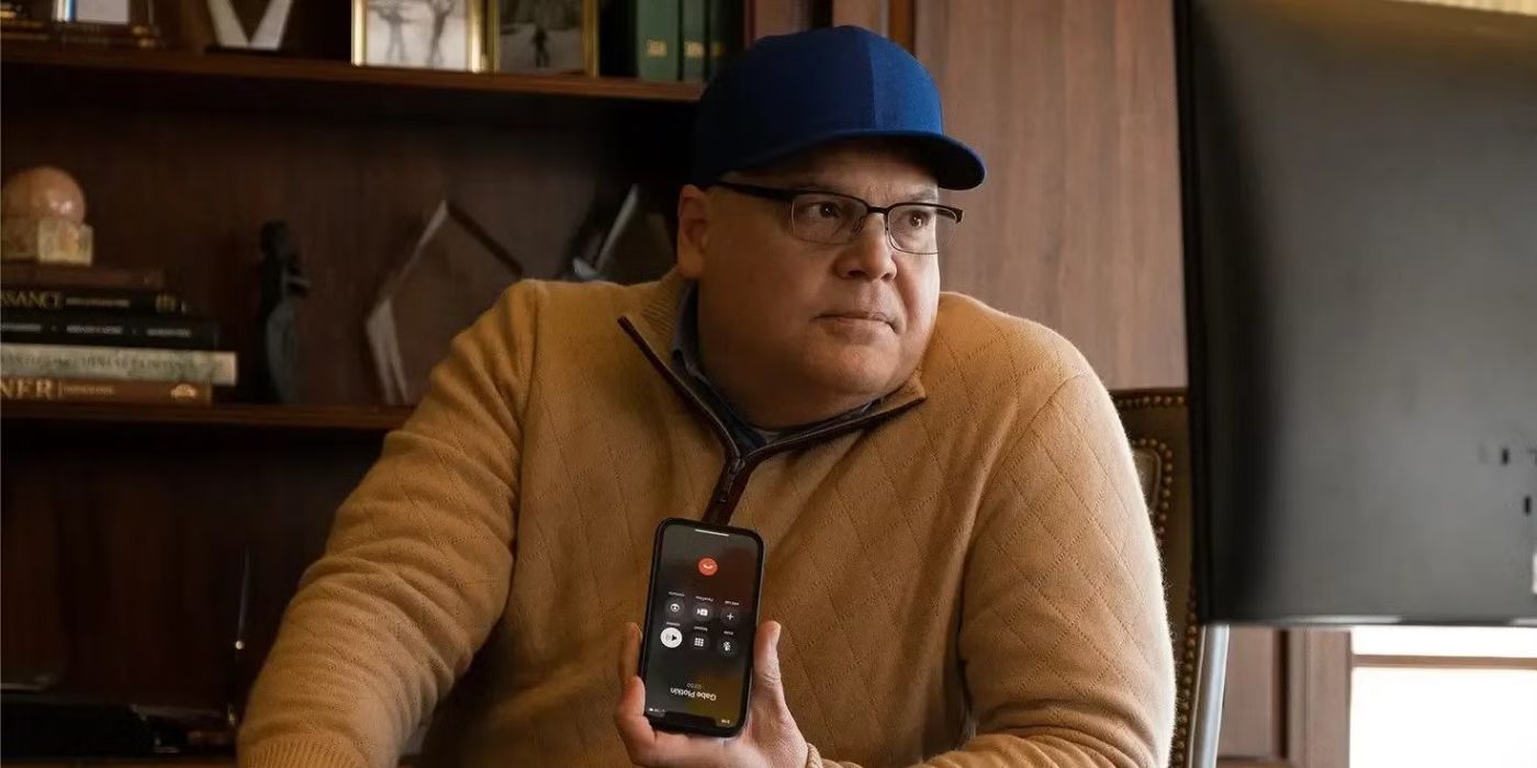 Vincent D&rsquo;Onofrio as Steven Cohen sitting at a desk holding a smartphone in Dumb Money.