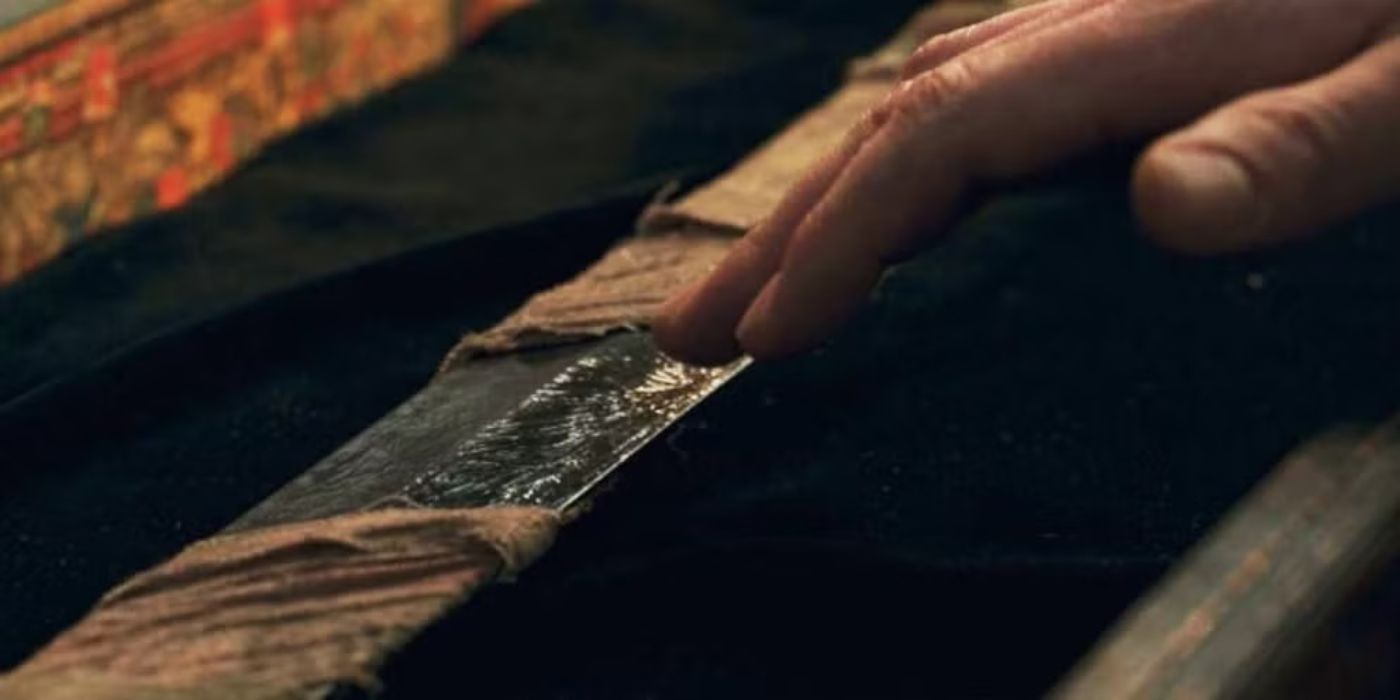 A hand reaches towards The Black Knight's Sword that is wrapped in cloth in an Eternals post credit scene.