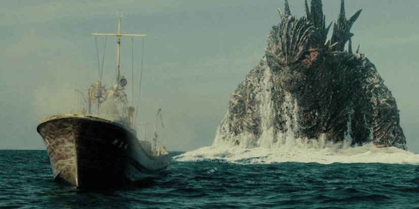 Godzilla rises out of the ocean behind a fishing boat in Godzilla Minus One.