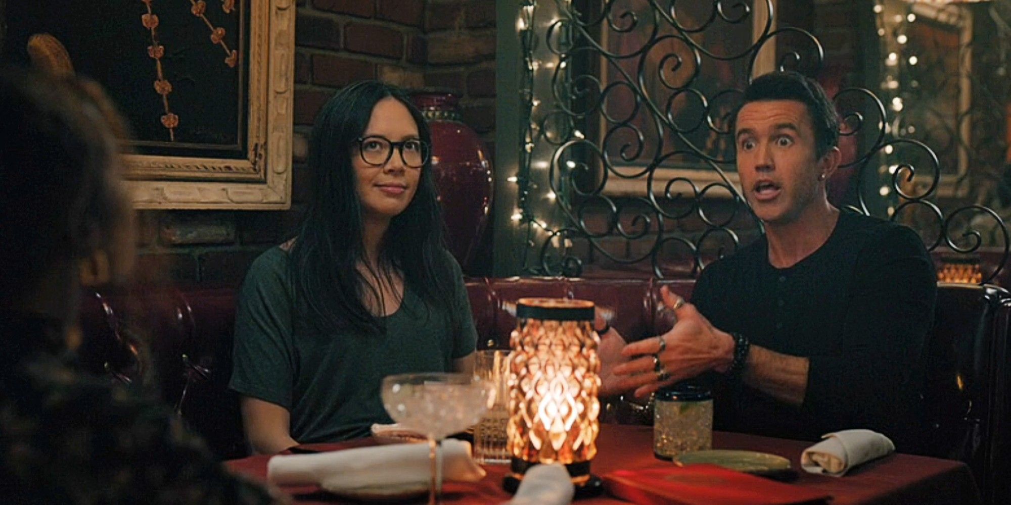 Poppy Li and Ian Grimm sitting at a restaurant table together in Mythic Quest Season 4