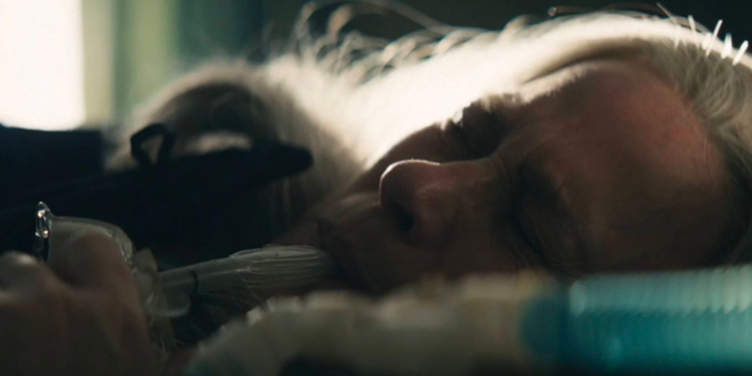 A closeup shot of Patricia Arquette&rsquo;s face as Harmoney Cobel crying and breathing through her mother&rsquo;s machine in Severance Season 2.