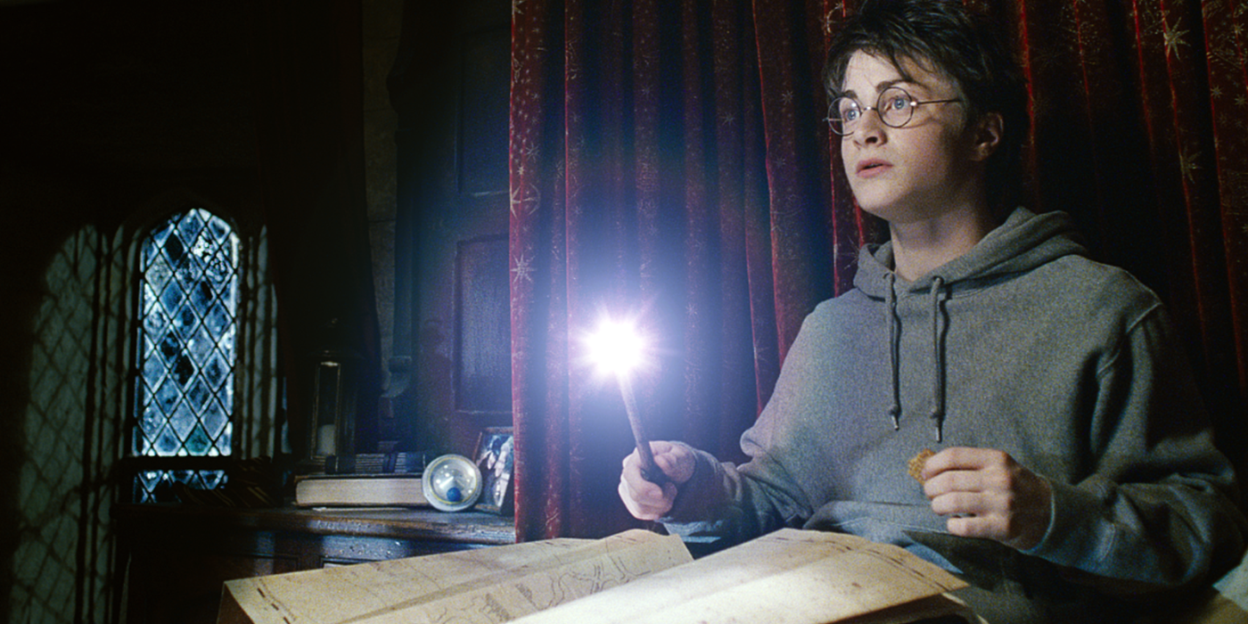Harry reads the Marauders' Map in his dorm room with the wand lighting it in the Harry Potter movie series.