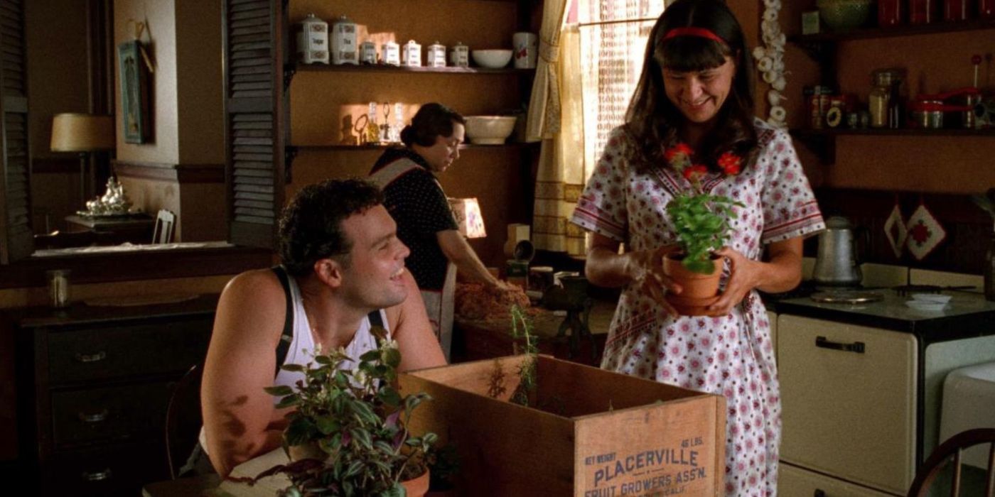 Vincent D&rsquo;Onofrio smiling at his wife with plants on the table in Household Saints.