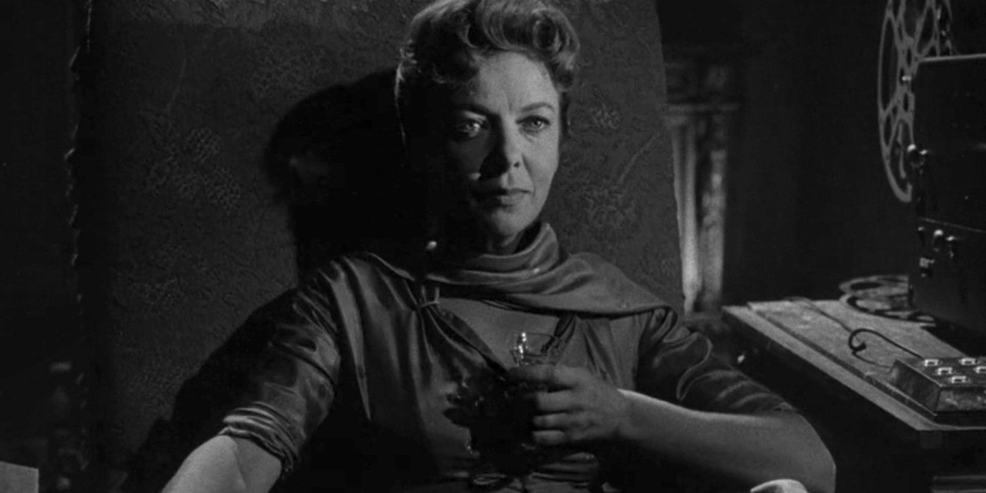 Ida Lupino, sitting in a chair drinking wine in "The Sixteen-Millimeter Shrine" episode of The Twilight Zone.