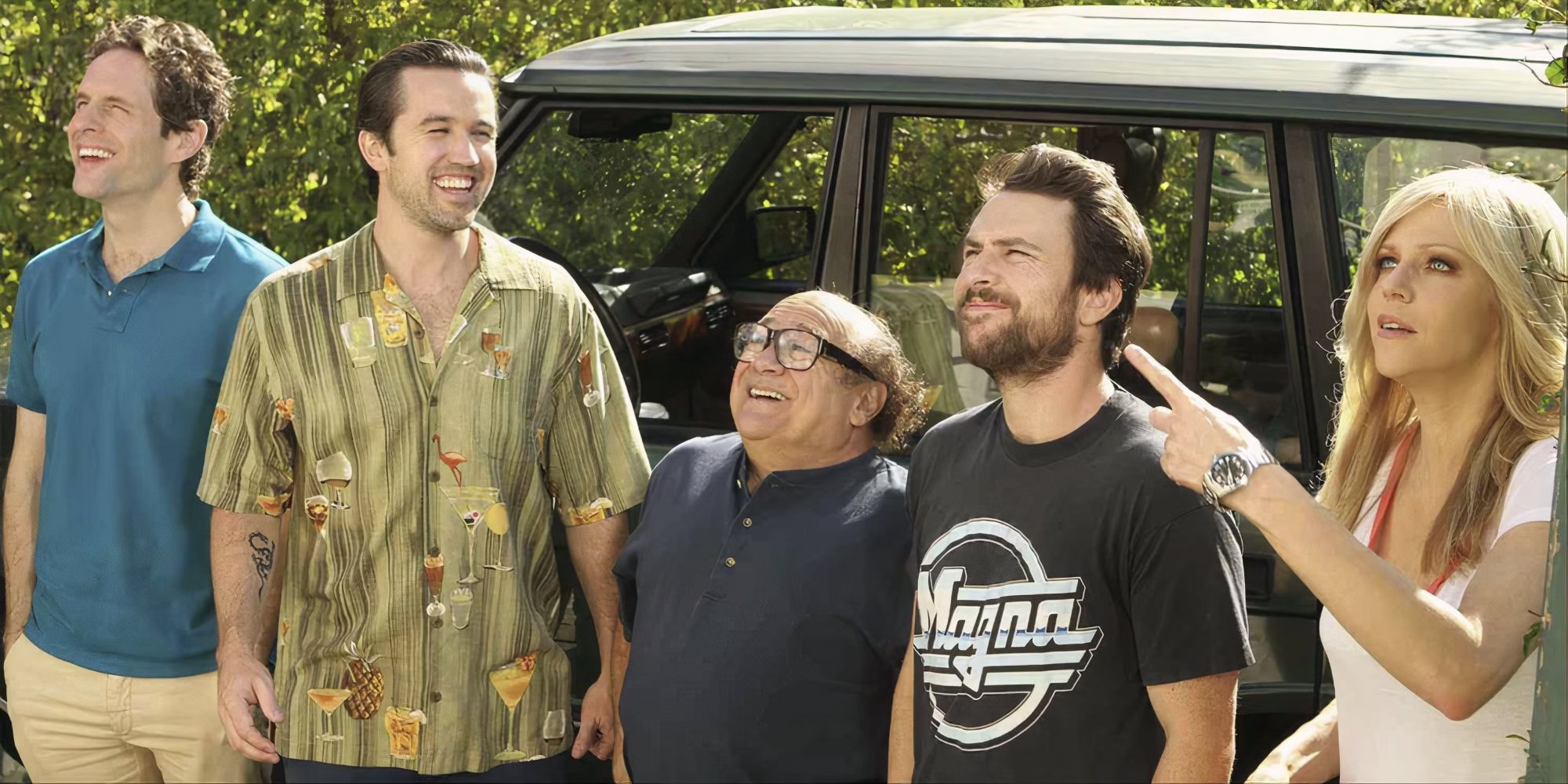 The cast of It&rsquo;s Always Sunny in Philadelphia stand in front of a car, look and smile at something off-camera