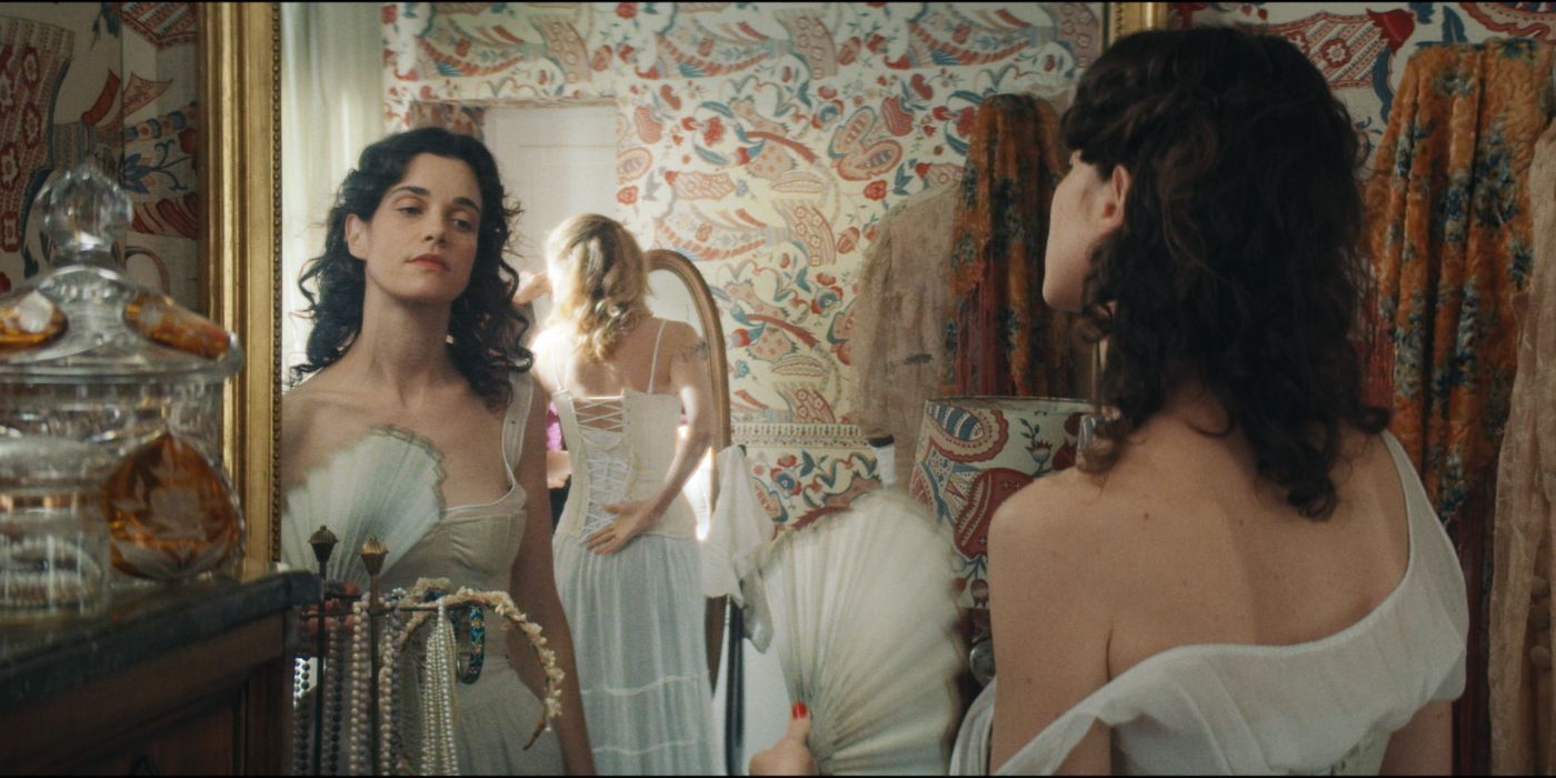 Camille Rutherford tries on a white wedding gown and looks at herself in the mirror