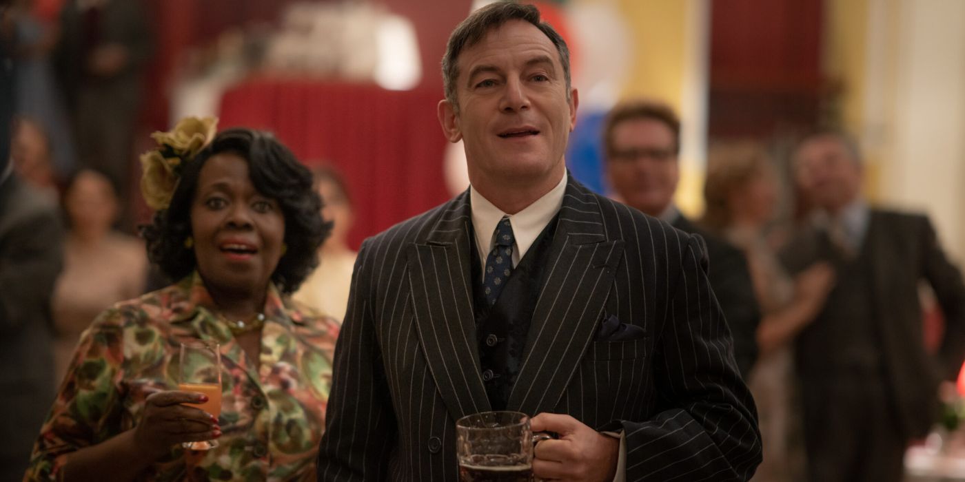 Jason Isaacs in awe holding a drink in Mrs. Harris Goes to Paris.