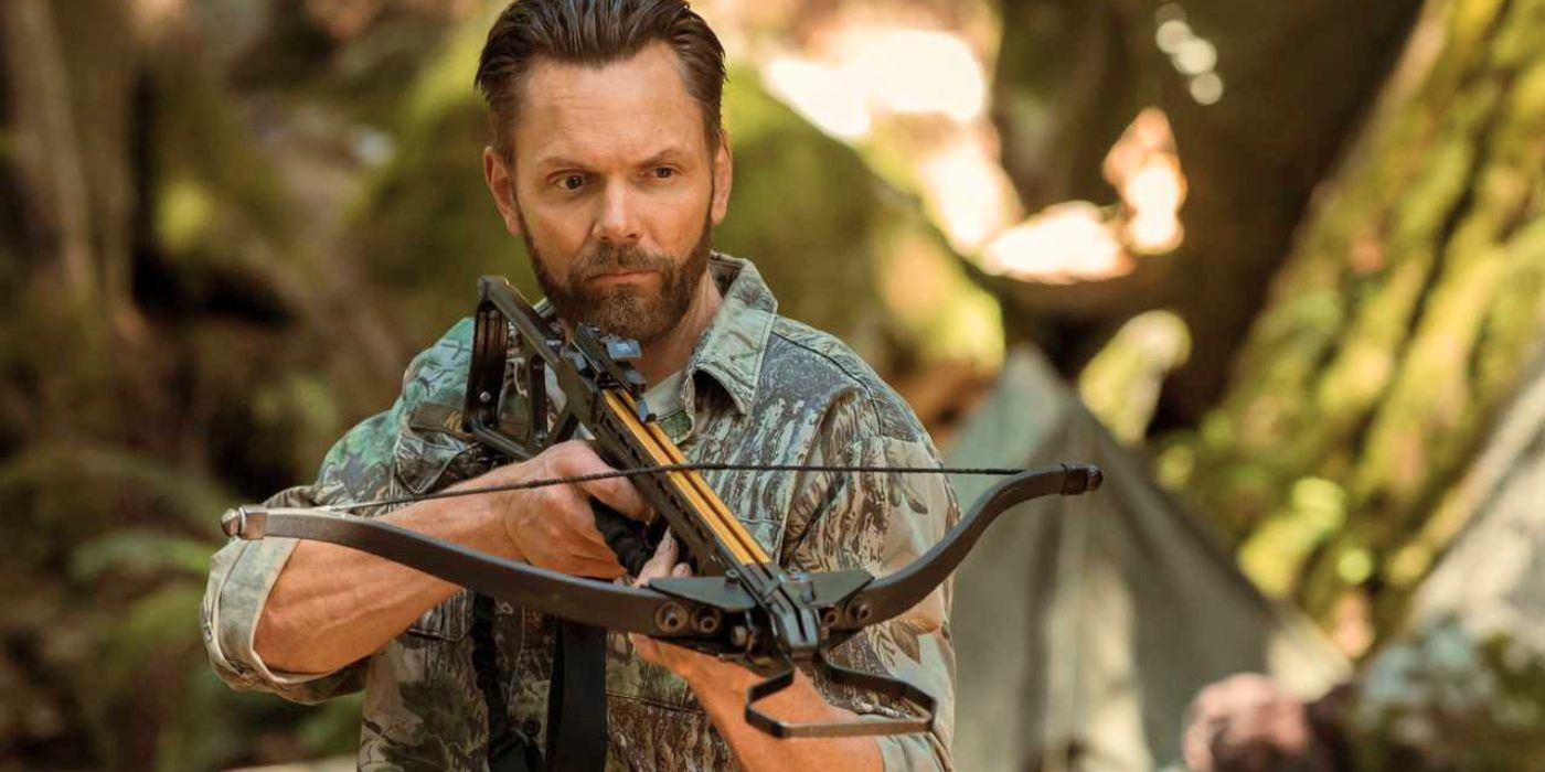 Joel McHale as Kodiak wields a crossbow in Yellowjackets