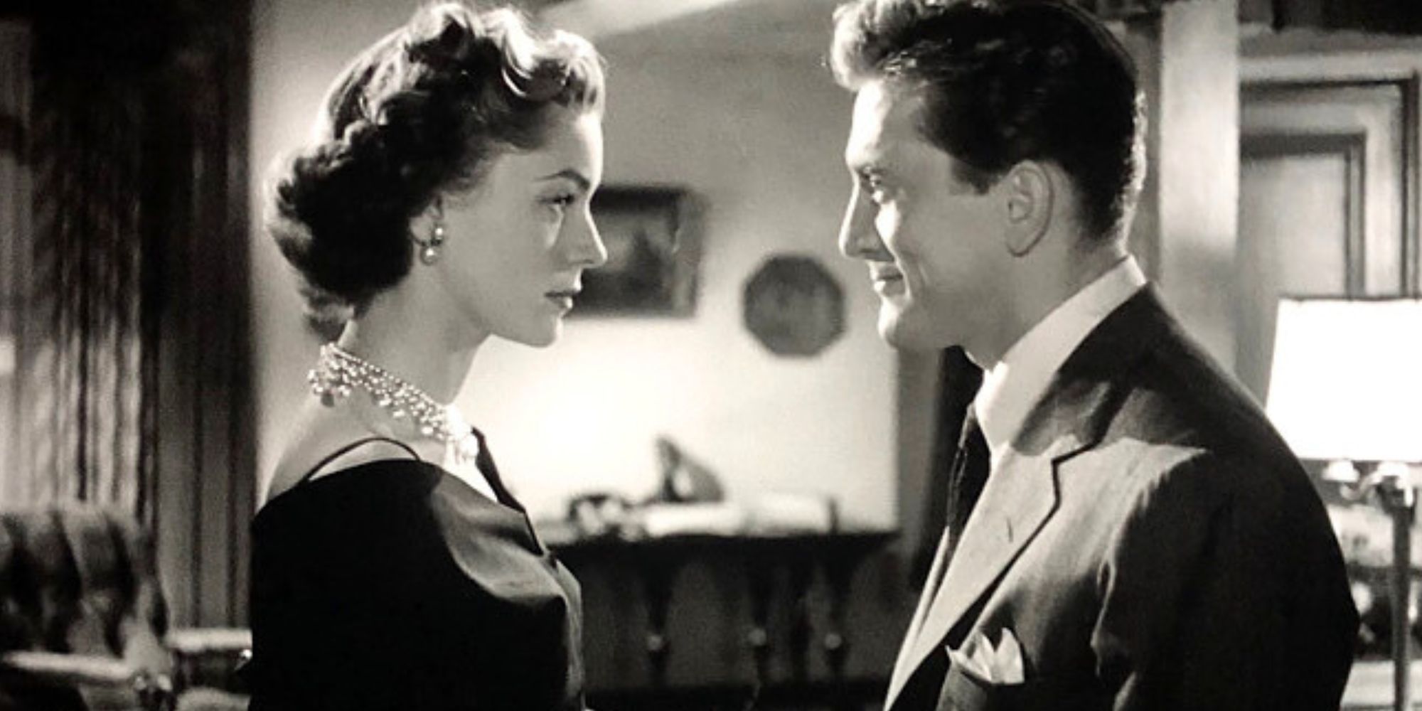 Lauren Bacall standing in front of Kirk Douglas in Young Man with a Horn (1950).