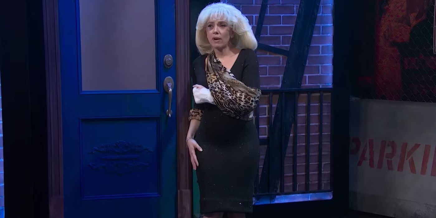 Actor Scarlett Johansson as Audrey on SNL50, wearing a black dress and leopard-print arm sling, with black eyes and a blonde bob hairdo.