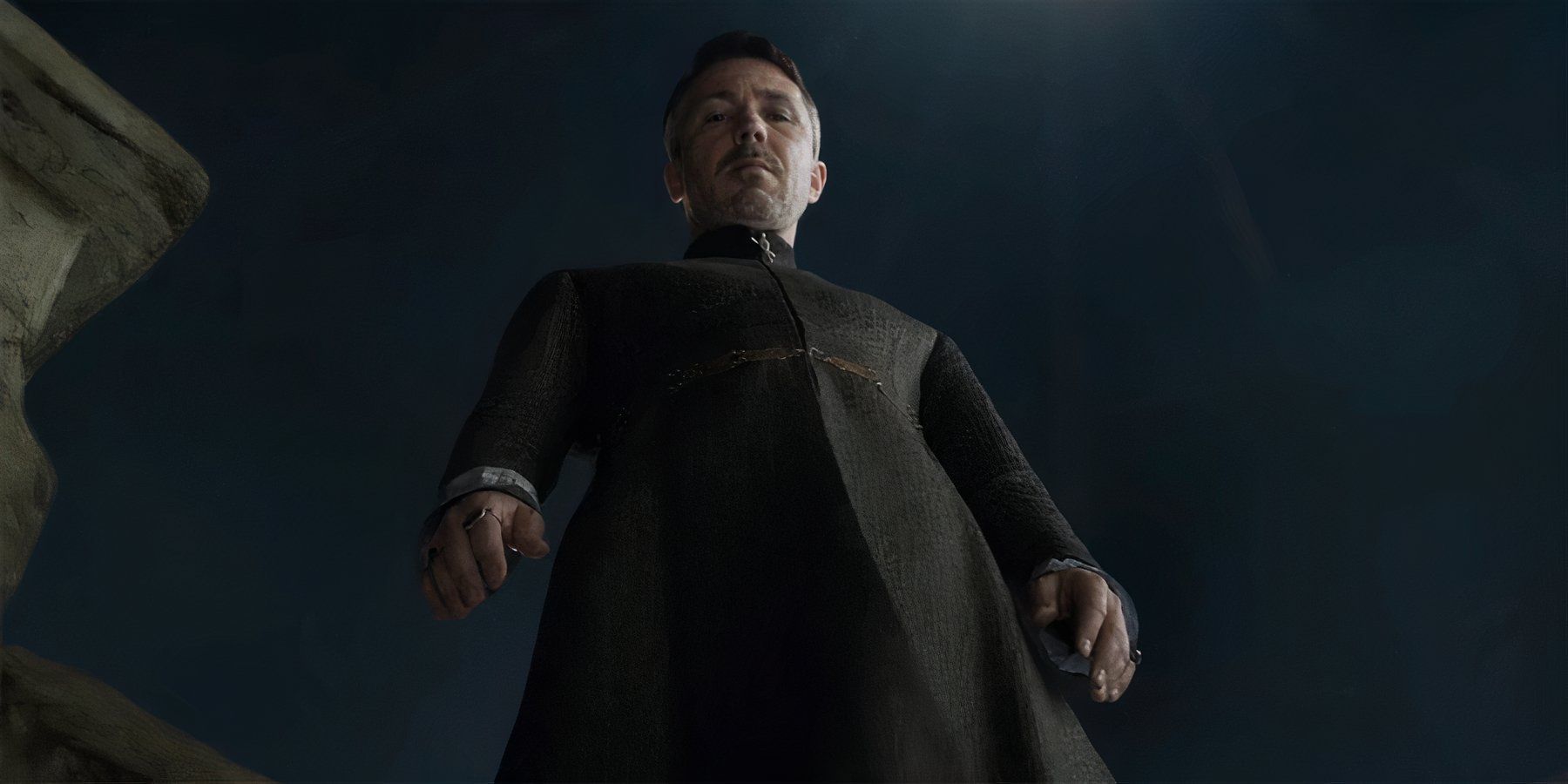 Littlefinger standing over a hole in a floor, he just pushed someone into, in the series Game Of thrones.