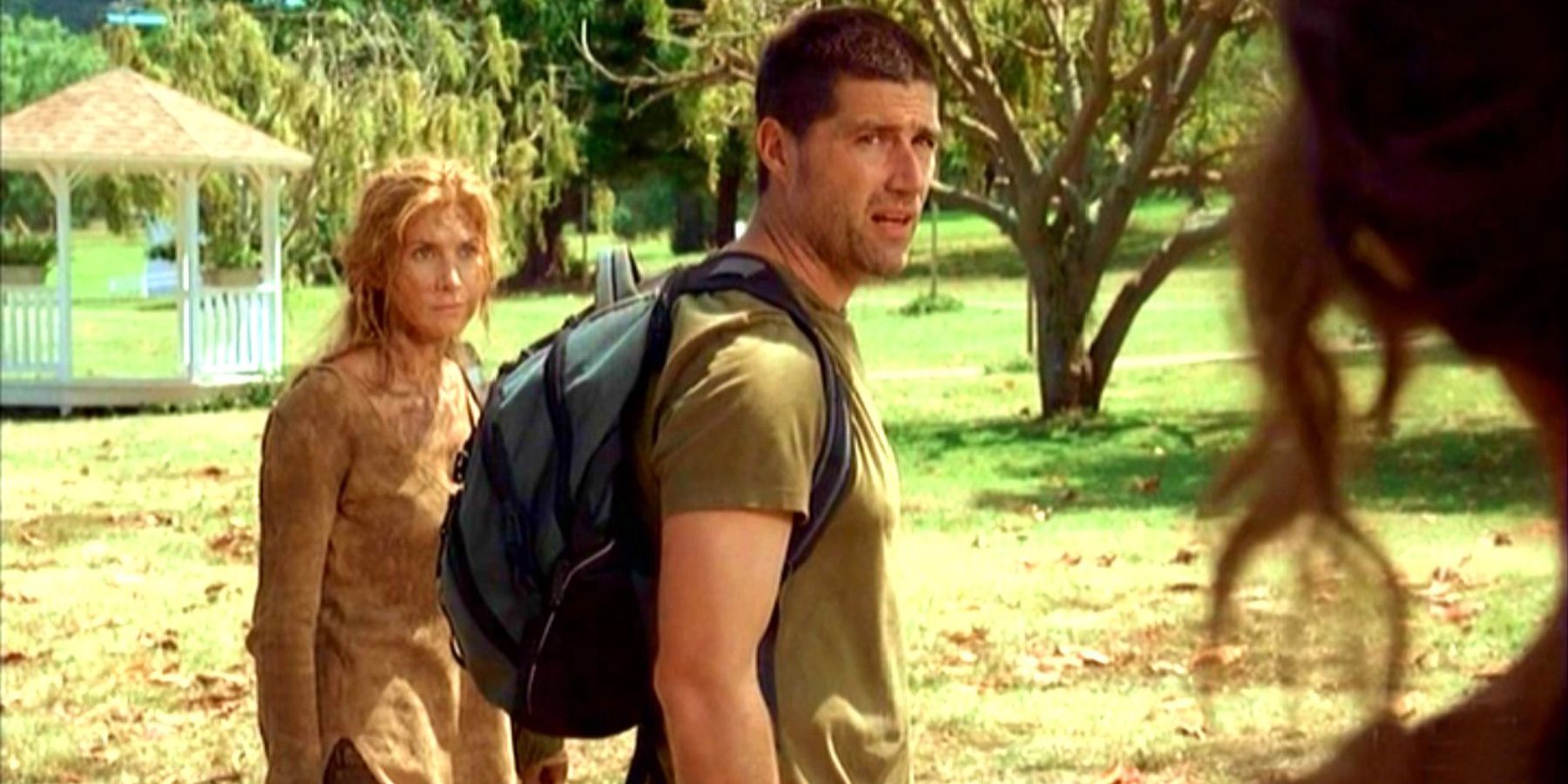 Jack in Lost is standing with a backpack and looking at someone.