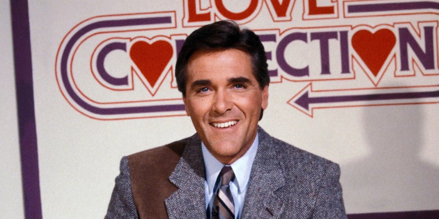 Chuck Woolery smiles with the logo for the game show he hosted, Love Connection, behind him.