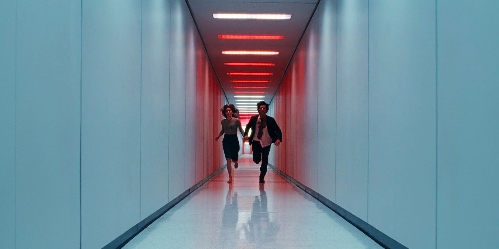 Mark S and Helly R run through a red-tinted hallway while holding hands in the Season 2 finale of Severance.