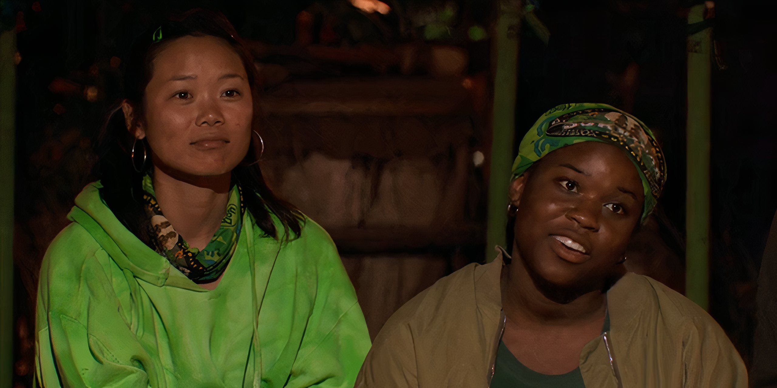 Mary Zheng and Sai Hughley sit together at night on Survivor