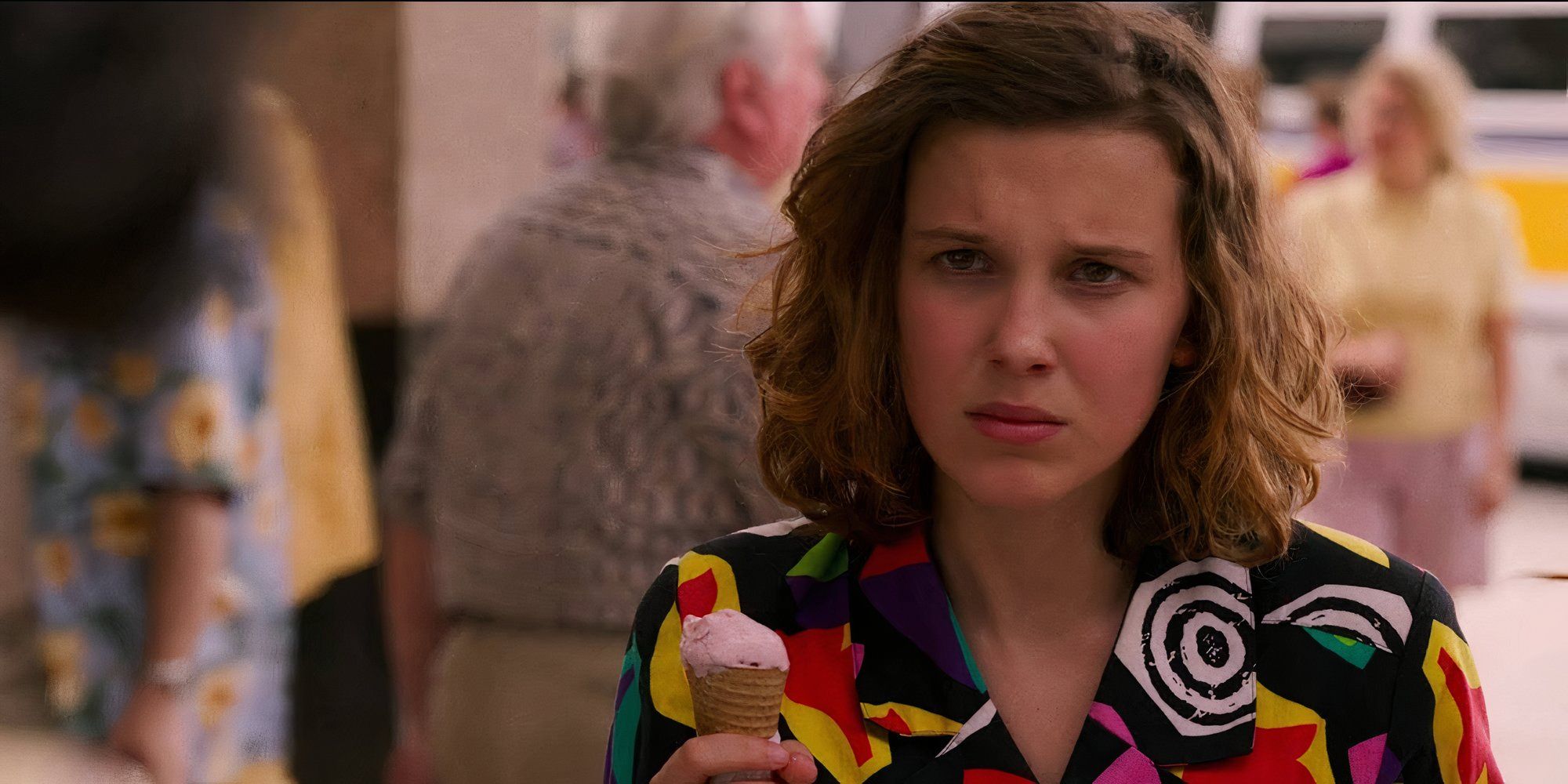 Millie Bobby Brown as Eleven in Stranger Things holding an ice cream and looking sad