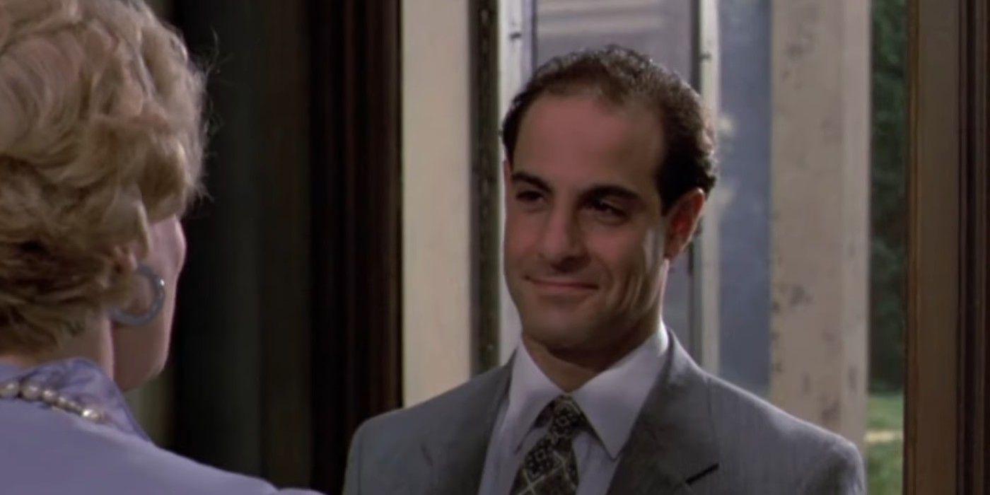 Stanley Tucci wearing a gray suit while standing in a doorway in Monkey Shines.