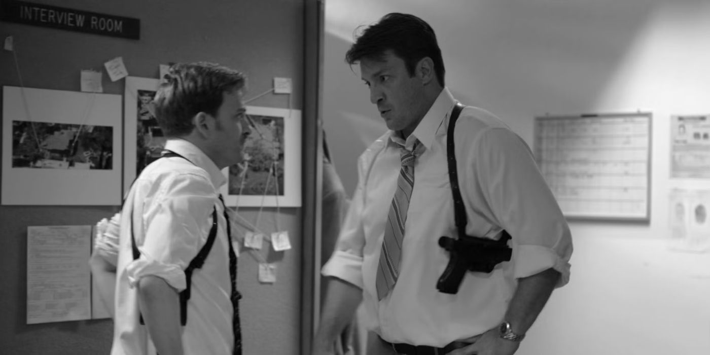 Nathan Fillion wearing a gun in a side holster talks to another person in an office in Much Ado About Nothing.