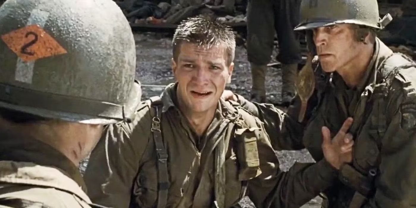 Nathan Fillion dressed as a soldier, crying with other soldiers near him in Saving Private Ryan.