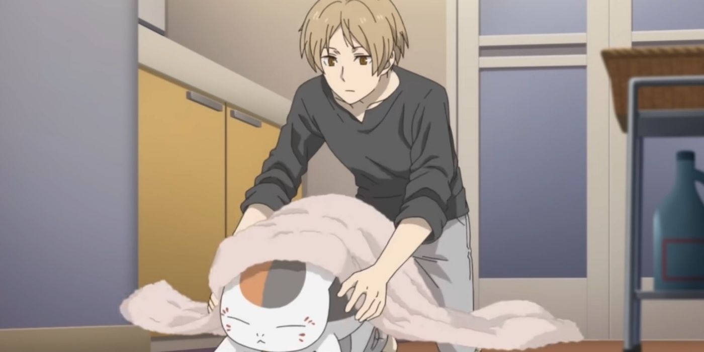 Natsume secando um gato espiritual no livro de amigos de Natsume