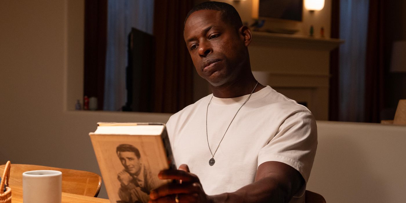 Sterling K. Brown looking at a hardback book in the Paradise finale