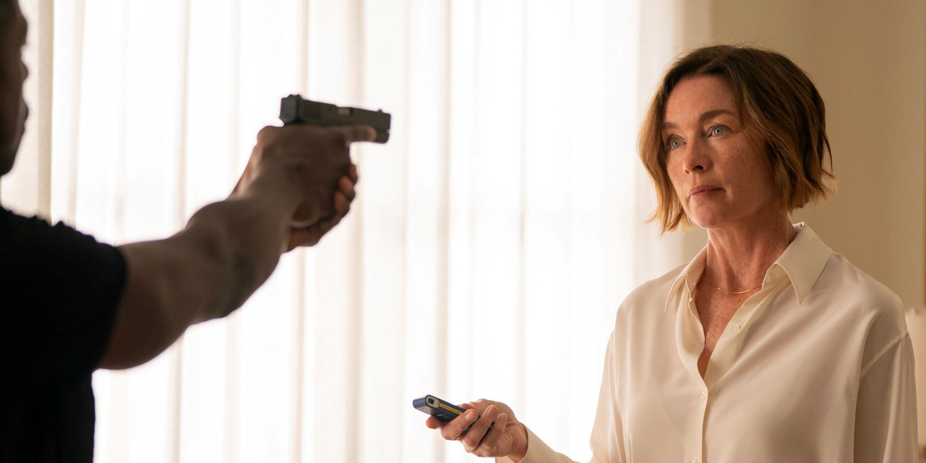 Julianne Nicholson as Sinatra with Sterling K. Brown as Xavier holding a gun to her head in Paradise