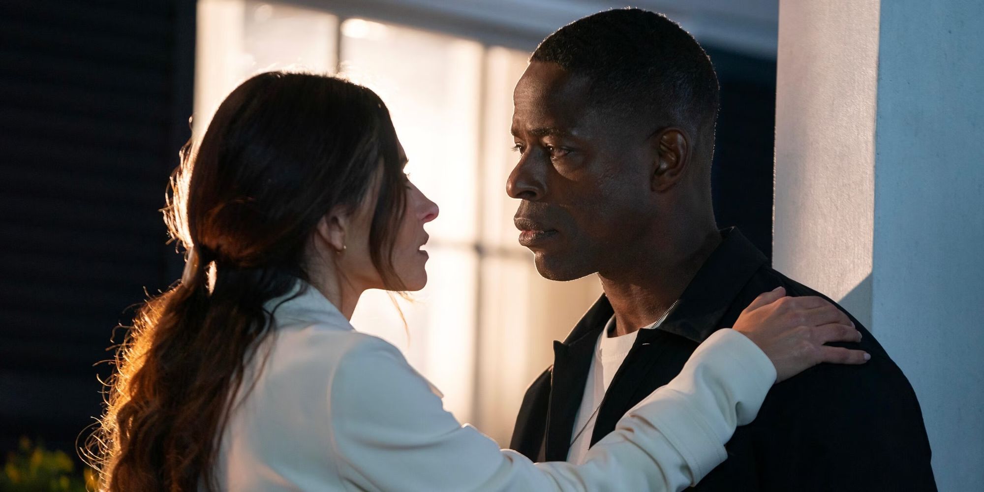 Sterling K. Brown as Xavier standing with Sarah Shahi as Gabriela with her arm on his shoulder in Paradise.