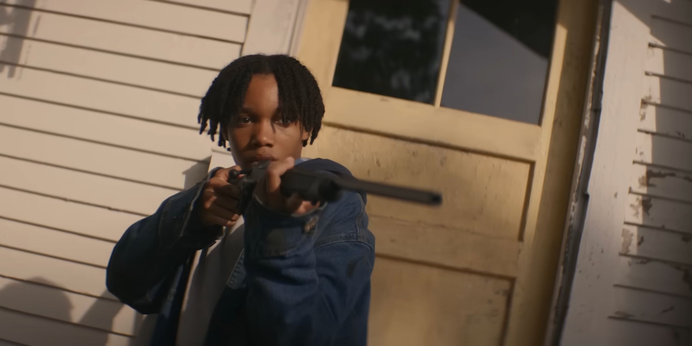 Peyton Jackson pointing a rifle in The Woman in the Yard
