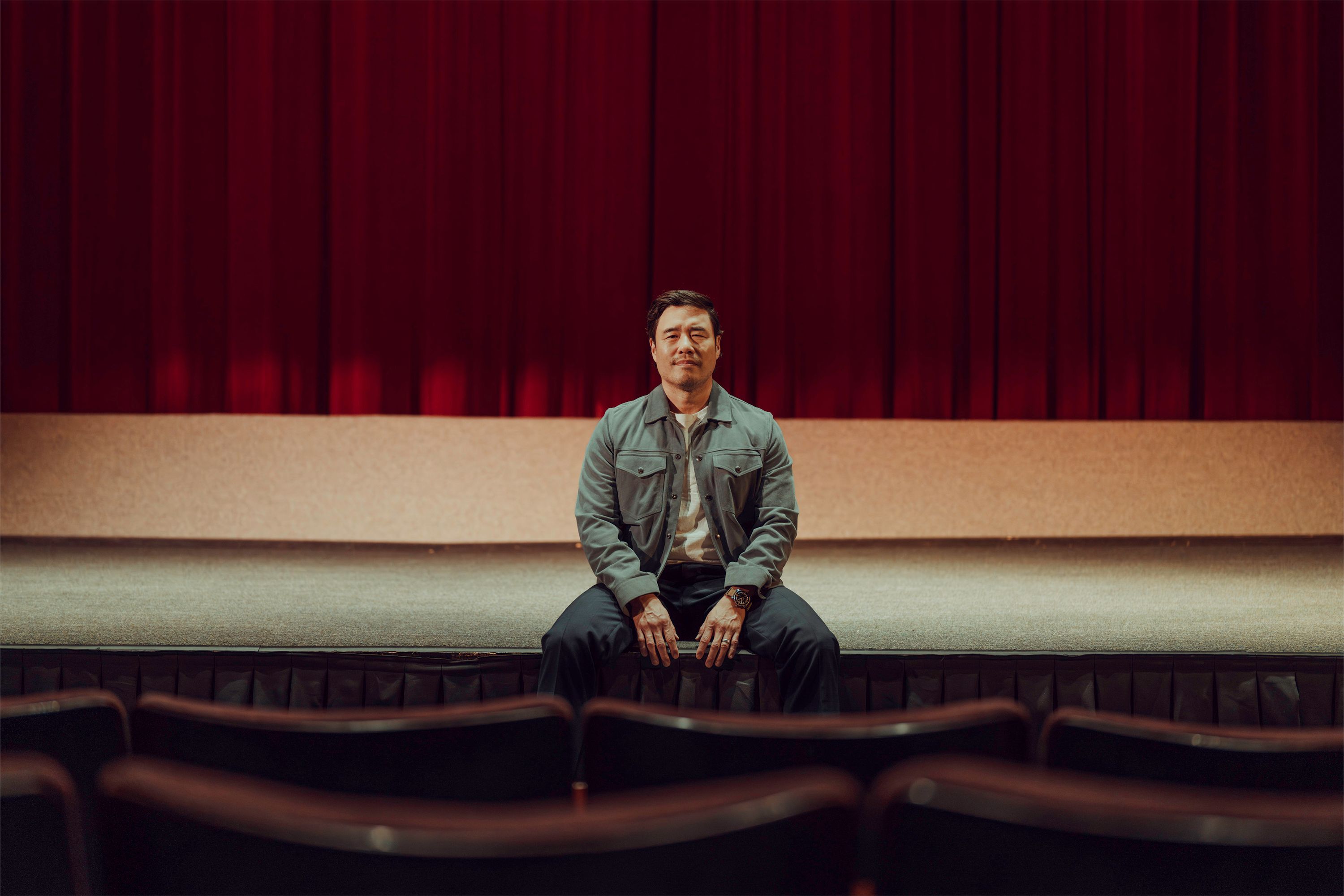 Randall Park sits on a stage at UCLA in photography by Hamish Robertson