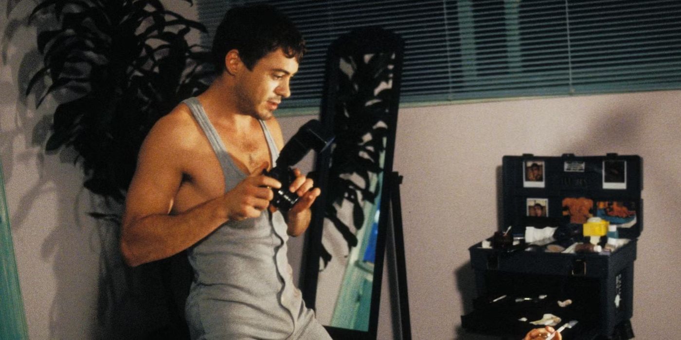 Robert Downey Jr. on a bed in a oneside holding a camera in Short Cuts