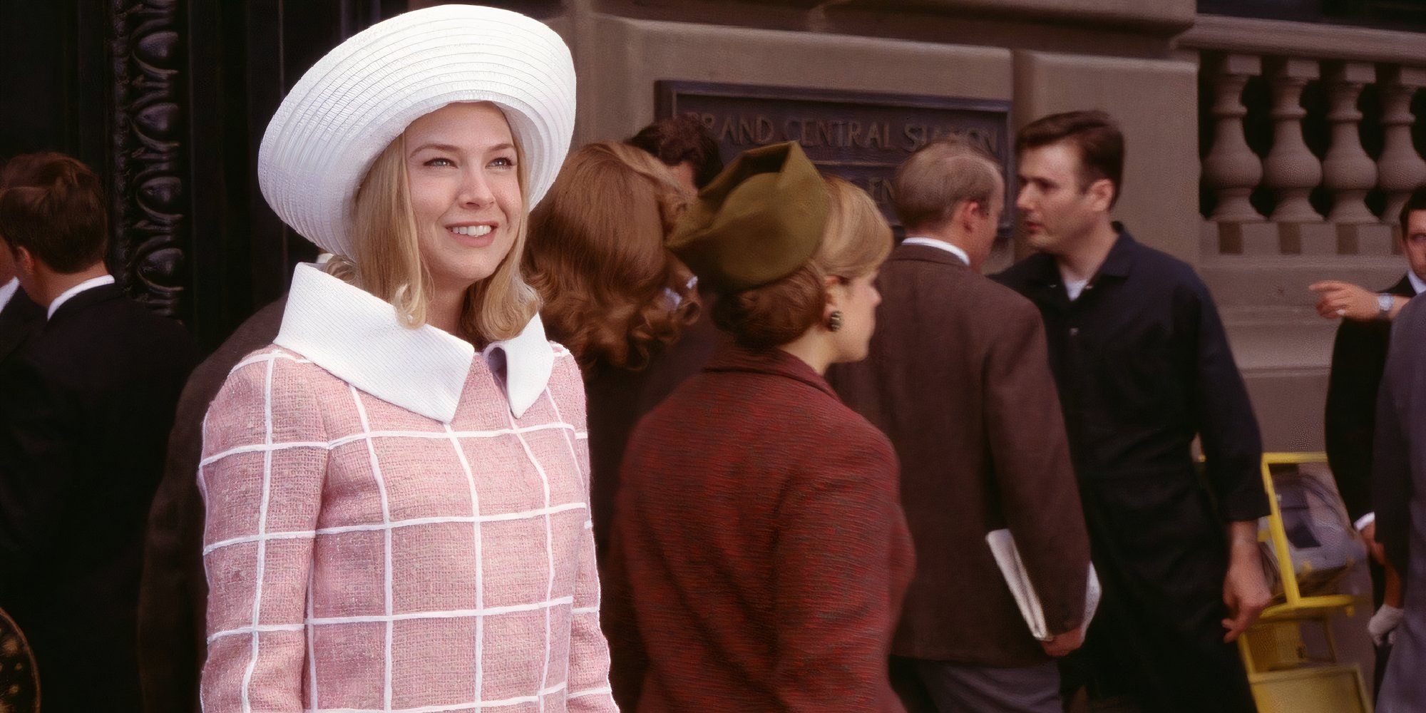Renée Zellweger in Down With Love smiling while standing on the street.