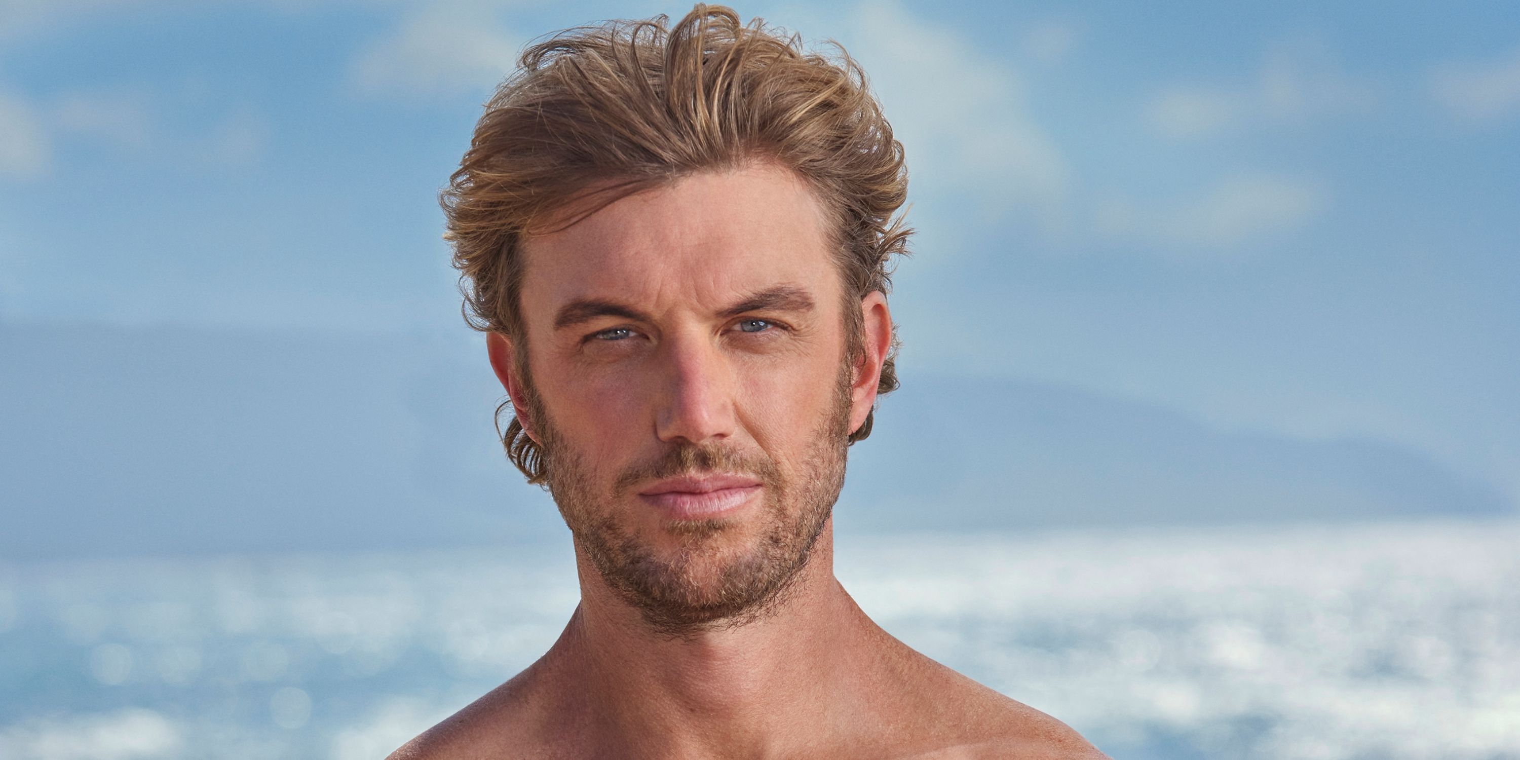 Adam Demos as Will in a promo shot shirtless and looking in the camera on the beach in Rescue: HI-Surf