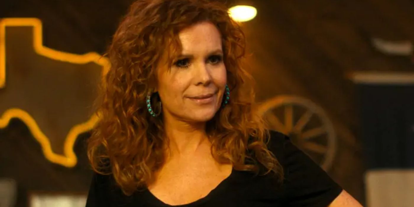 Robyn Lively as Ellie, a waitress in Landman, talks and smiles at someone in front of her who is off-screen.