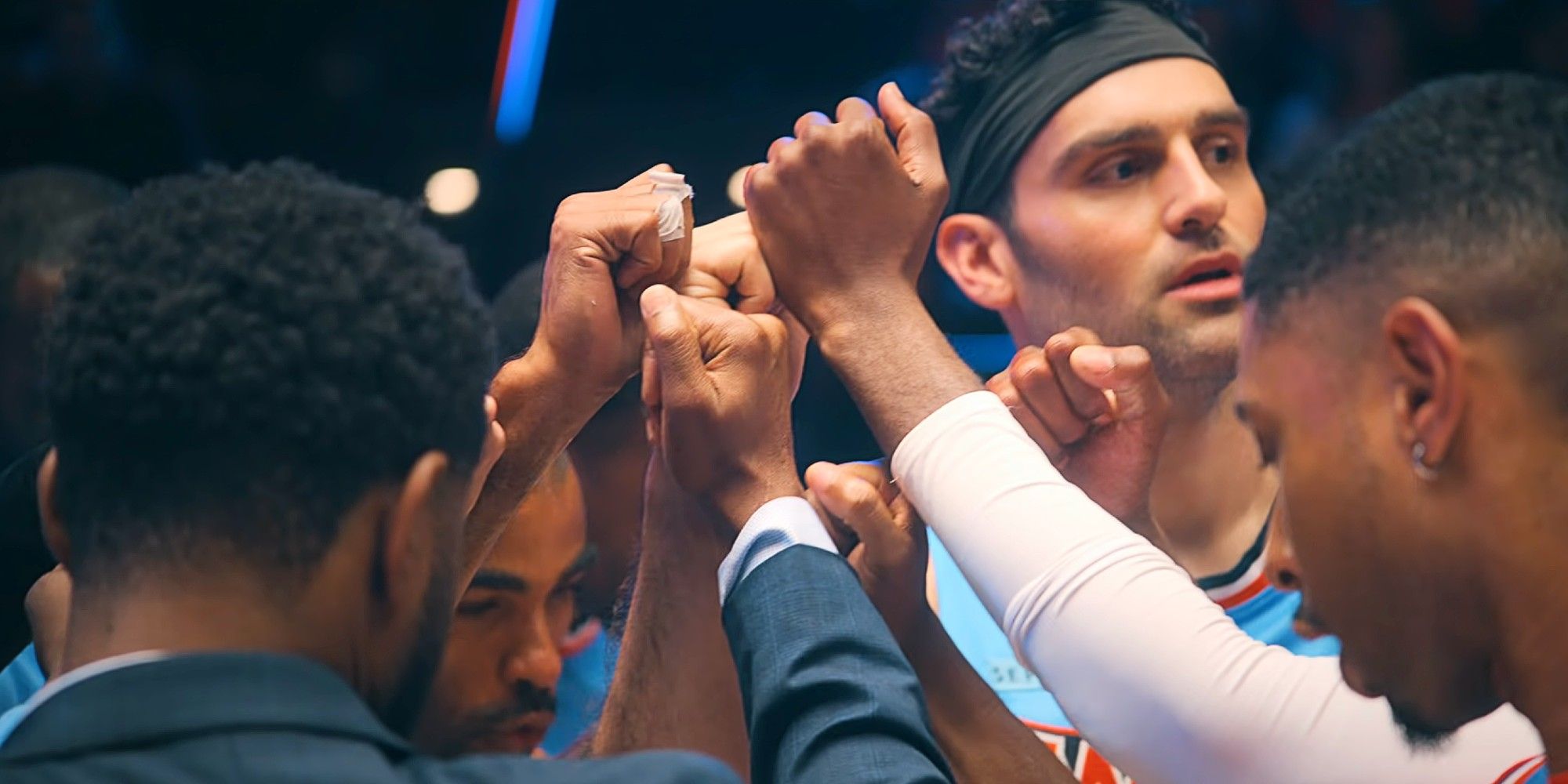 The Waves team touching fists at the basketball game in Running Point