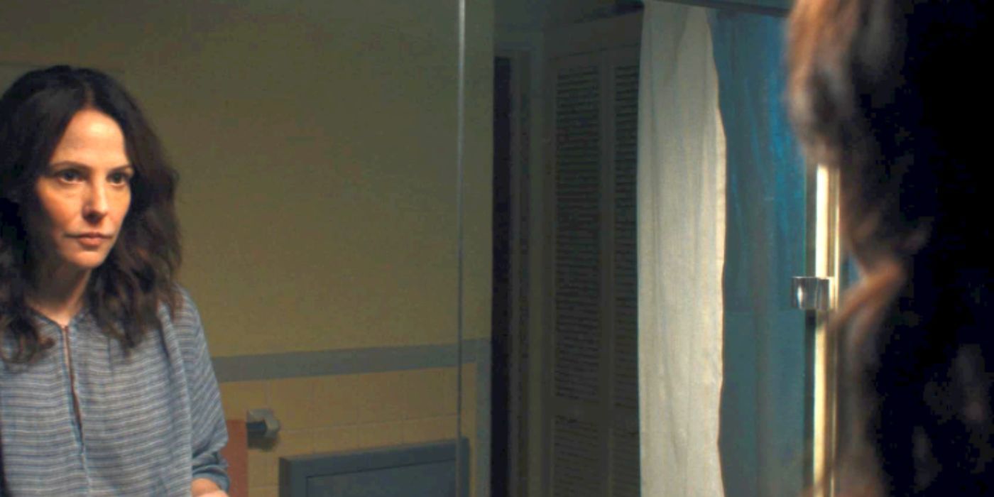 Mary-Louise Parker as Zoya wearing a stripped shirt looking at herself in the mirror in &lsquo;Omni Loop&rsquo;