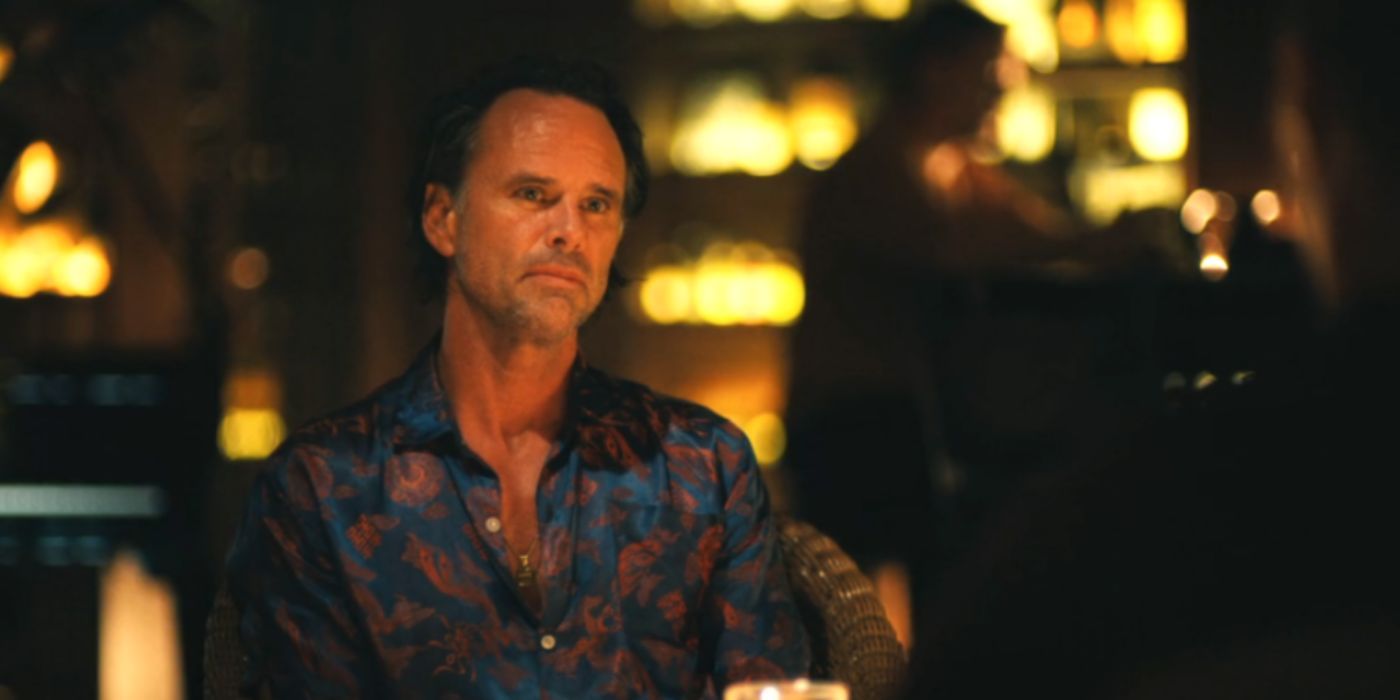 Walton Goggins as Rick wearing a blue shirt sitting in a restaurant in 'The White Lotus'.