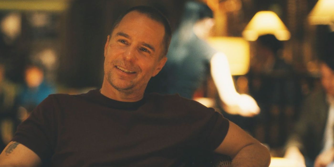 Sam Rockwell como Frank usando uma camisa marrom sorrindo em um restaurante em 'The White Lotus'