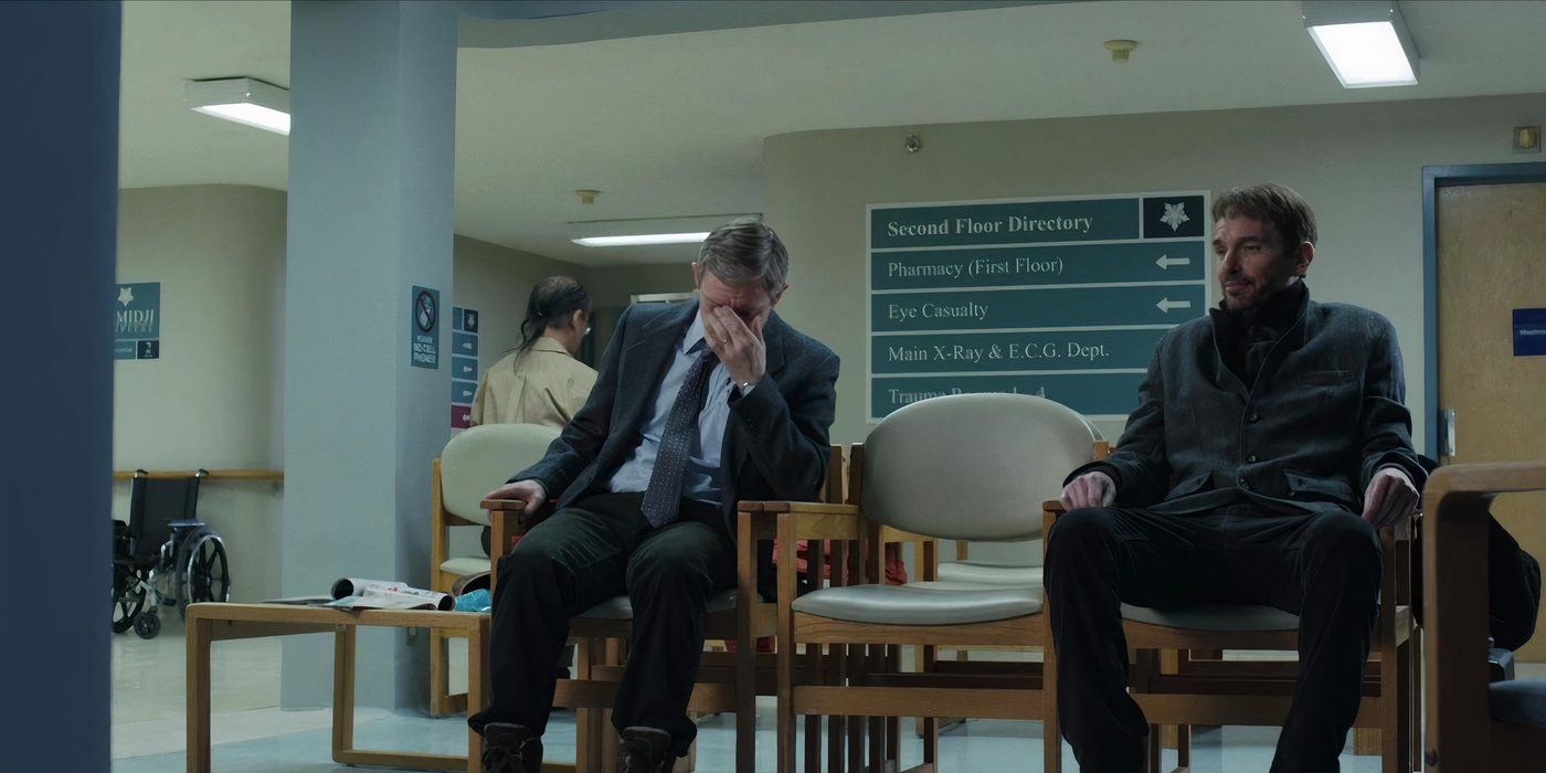 Lester Nygaard and Lorne Malvo are sitting in the hospital waiting area. Lorne looks peaceful, Lester looks distressed with his hand on his face.