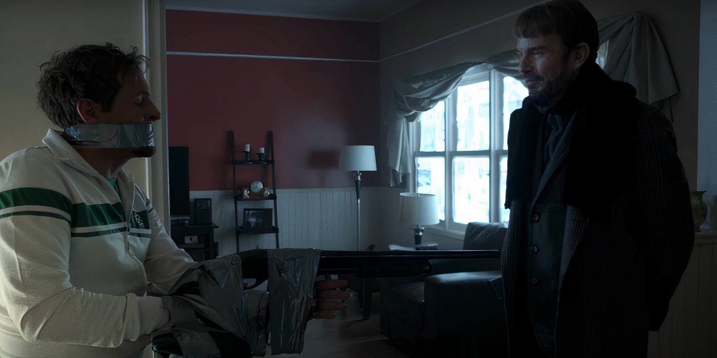 Malvo taunts a tied up Don Chumph after taping his hands to an empty shot gun in a dimly lit house.