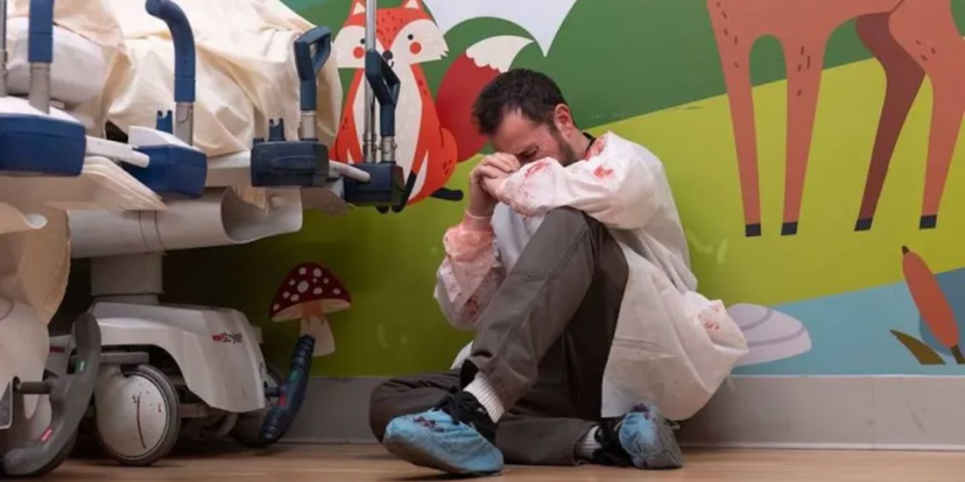Noah Wyle as Dr Robby wearing white scrubs sitting down and crying in &lsquo;The Pitt.'