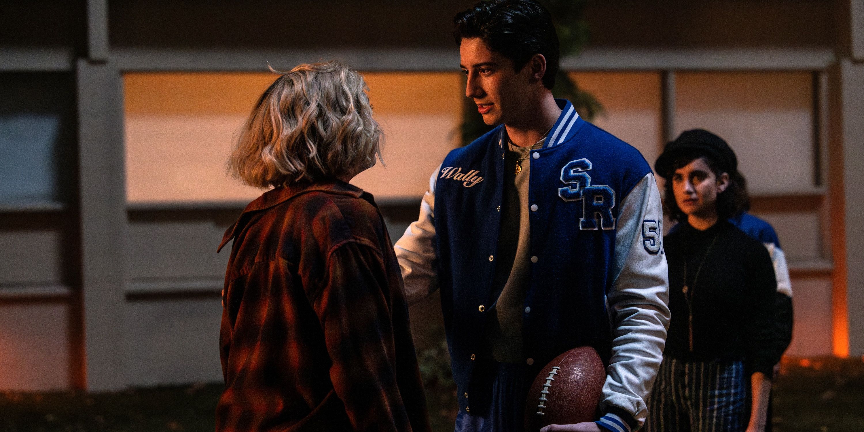 Peyton List as Maddie with Milo Manheim as Wally holding her left arm with his right hand in School Spirits
