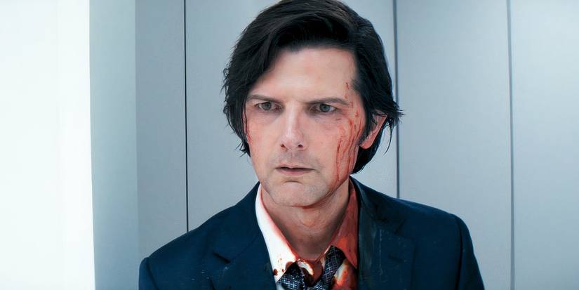 Adam Scott como Mark, luciendo serio con sangre en su rostro en el final de la segunda temporada de Severance.