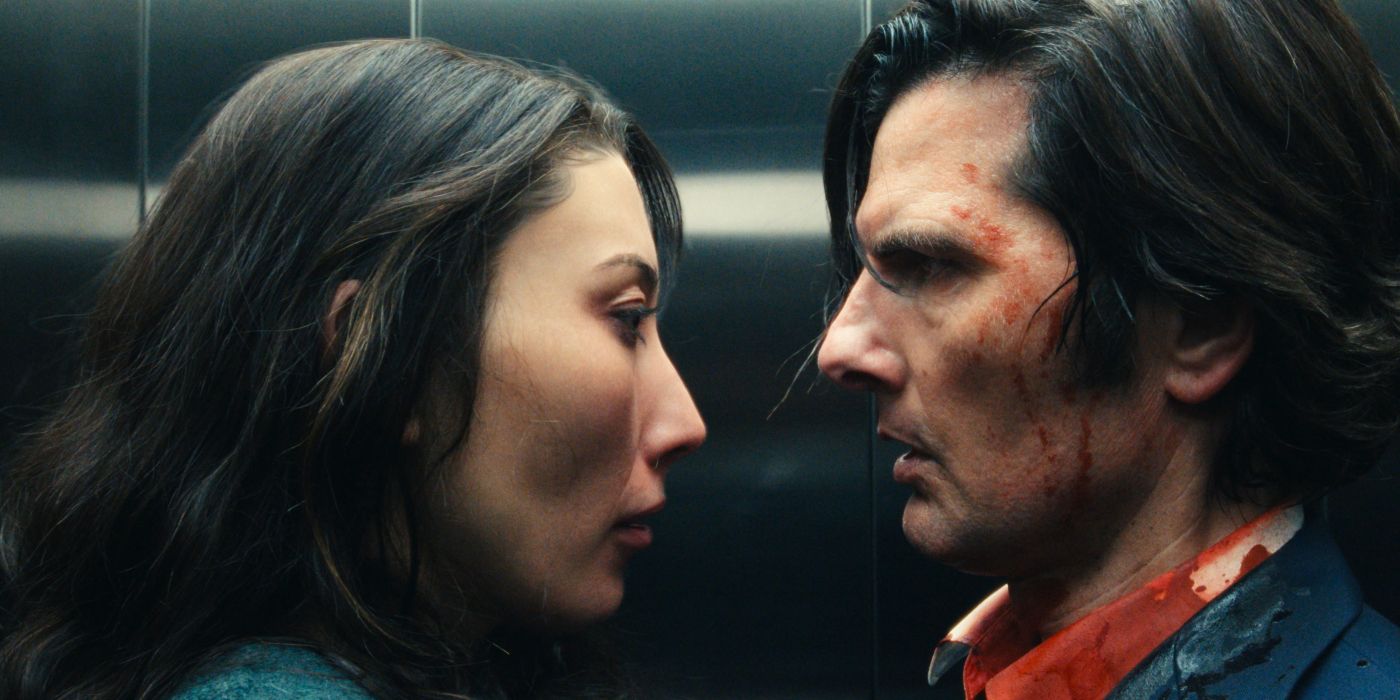 Dichen Lachman and Adam Scott standing closely in an elevator