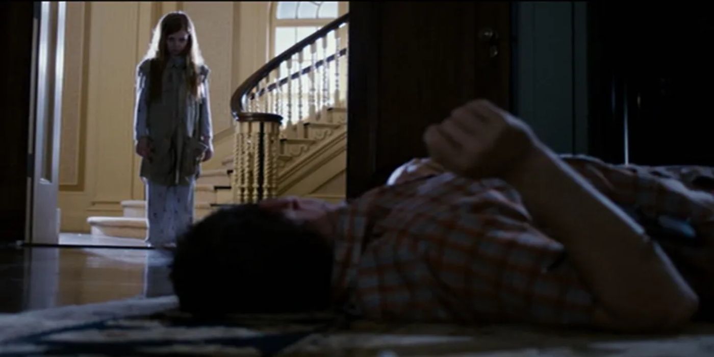 A young girl looking at a man laying on the floor bleeding in &lsquo;Sinister&rsquo; (2012)