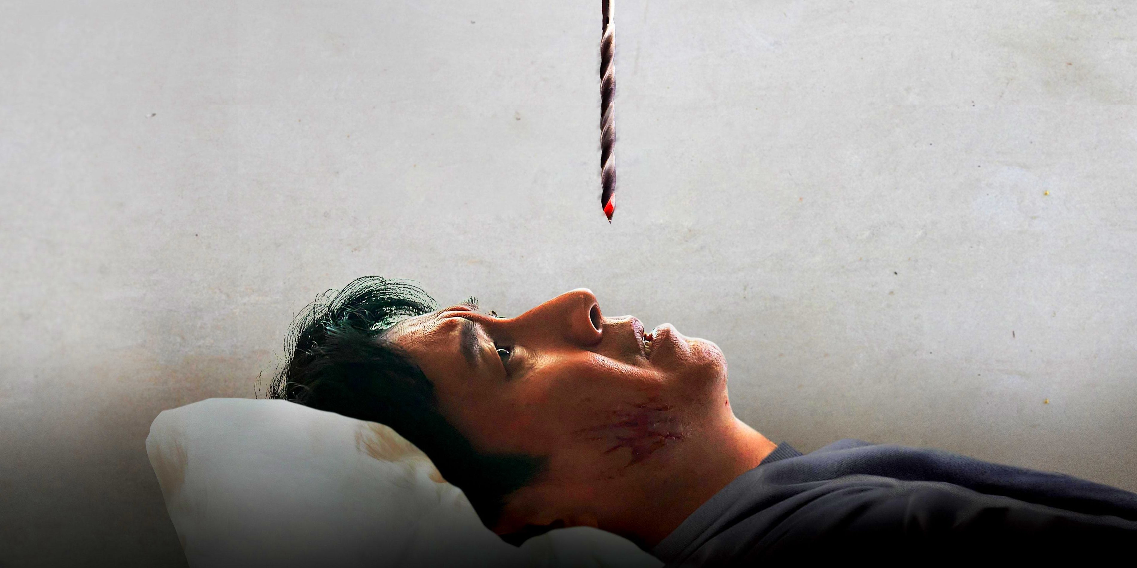 Hyun-su, played by actor Lee Sun-kyun, lies in bed looking up at a bloody drillbit hanging above his face in Sleep.