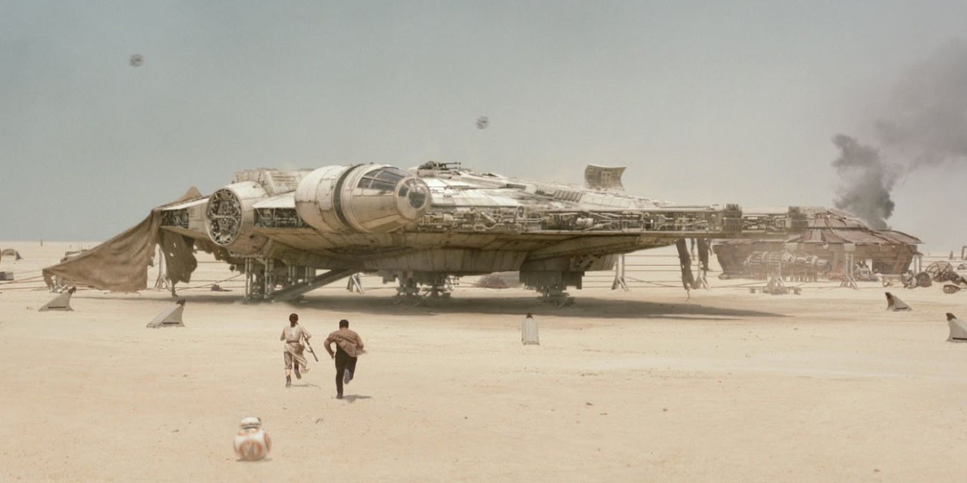 Rey (Daisy Ridley) and Finn (John Boyega) run toward the Millenium Falcon in Star Wars: The Force Awakens.