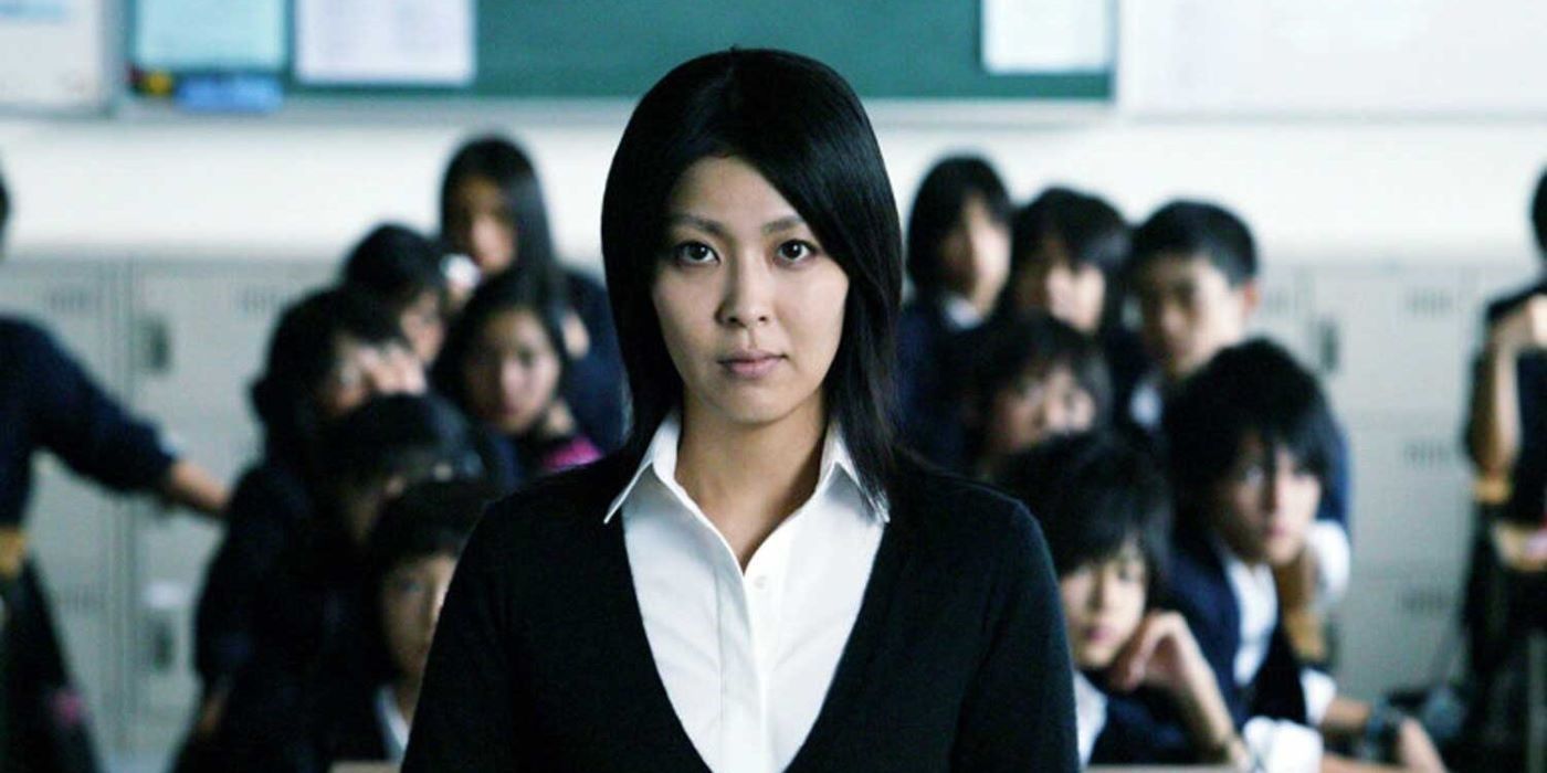 Takako Matsu as Yuko looking at the camera in a classroom with other students in Confessions
