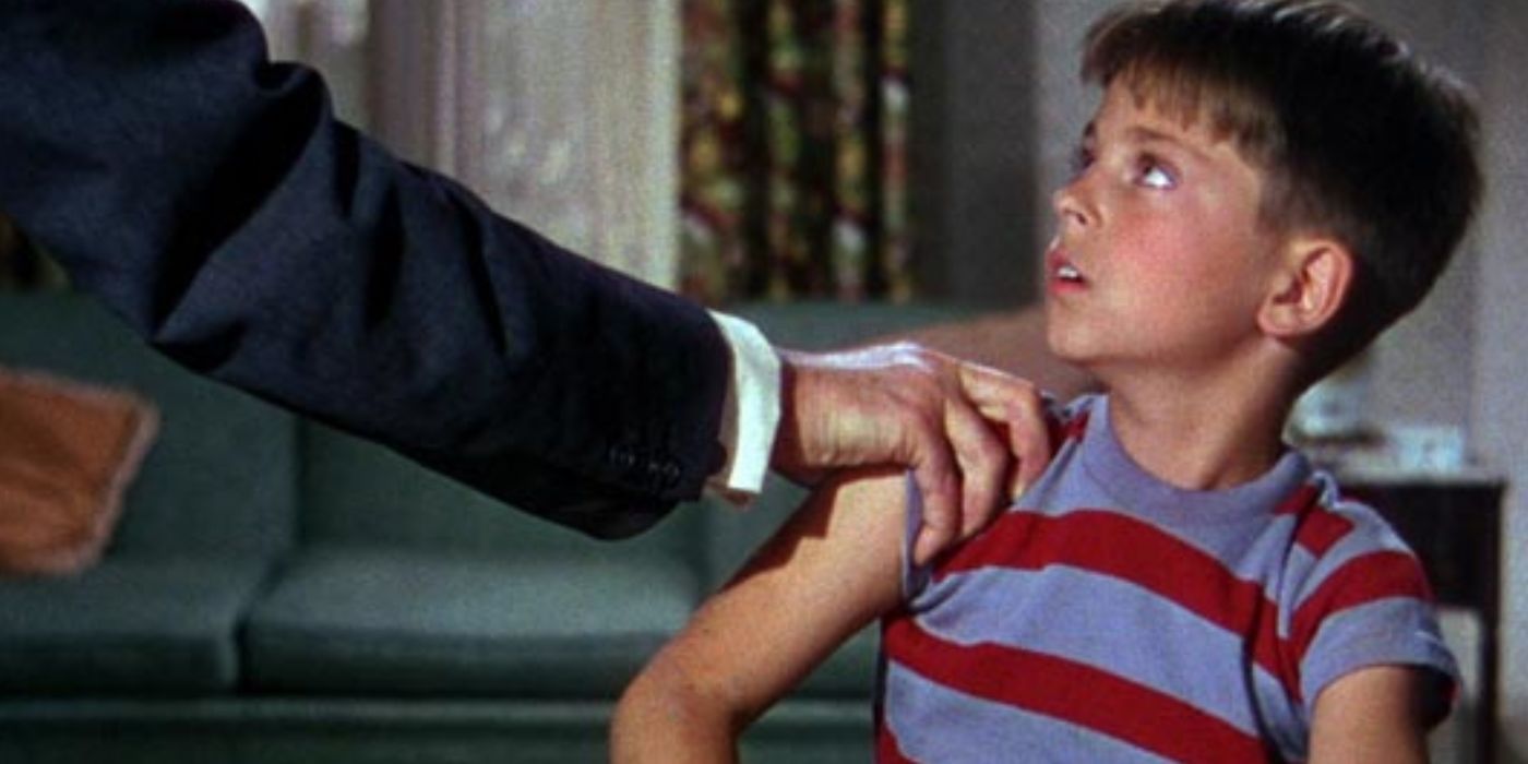 Hans Conried as Dr. Terwilliker grabs Tommy Rettig as Bartholomew Collins's arm from offscreen in The 5000 Fingers of Dr. T