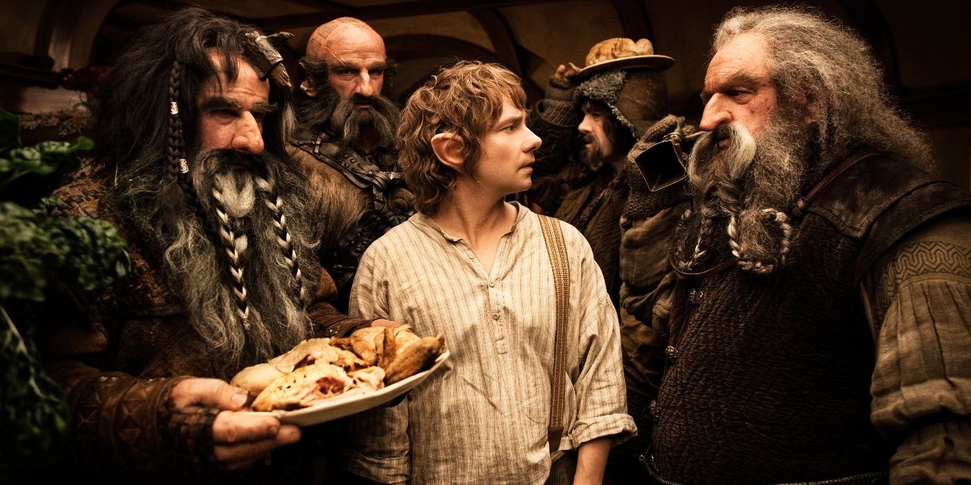 Martin Freeman as Bilbo Baggins, Graham McTavish Dwalin, and John Callen as Oin holding a plate of food in The Hobbit