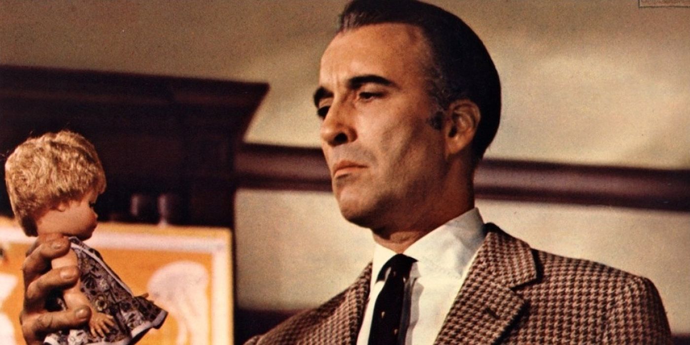 Christopher Lee as John Reid holding a doll in The House That Dripped Blood